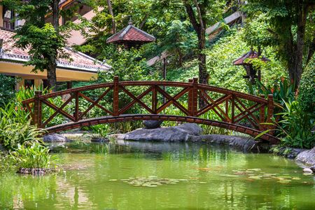 Arched bridge through a decorative pond on a Japanese tropical garden in Danang, Vietnam. Travel and nature conceptの写真素材