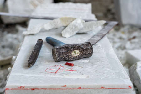 Sculptor tools on a marble slab, close up. Workplace, traditional tools sculptor, red chalk, ruler, hammer and chisel for working stone. Vietnam, Da Nangの写真素材