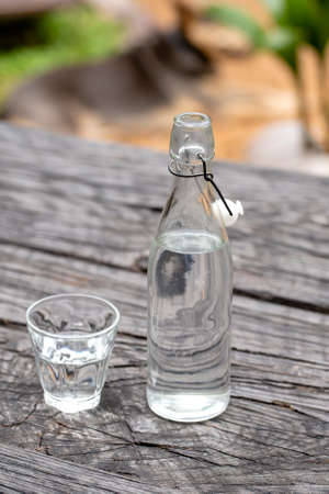 Bottle and glass with water on the wooden table, close upの写真素材