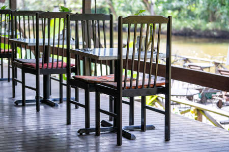 Wooden chairs and table on the backyard in tropical cafe near lake with beautiful view in island Borneo, Malaysia, close upの写真素材