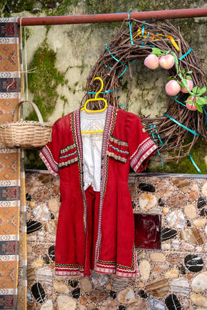 Georgian folk red costume for men hanging on a hanger in the yard. Batumi, Georgia