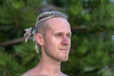 Portrait of a young guy with dreadlocks on his head in nature. Happy handsome man with dreadlocks on the tropical beach, close upの写真素材