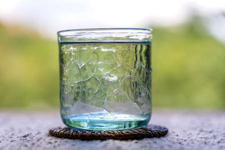 Glass with cool fresh water on a table outdoors, close upの写真素材