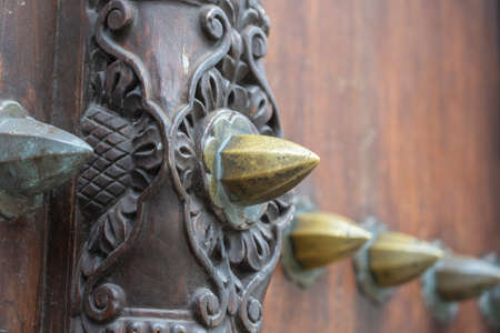 Close up of a ancient traditional wooden carved door with ornaments and bronze spike in Stone Town on island Zanzibar, Tanzania, East Africaの写真素材