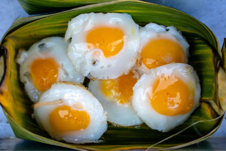 Fried quail egg In the container made of banana leaves is a street food in local market in Thailand,...