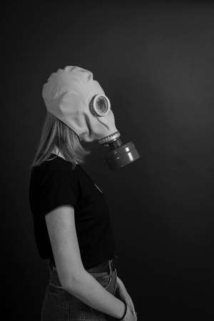 The girl in a gas mask on a black background, close up, black and whiteの写真素材