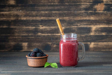 Fresh blackberry smoothie in the glass jar on wood  tableの写真素材