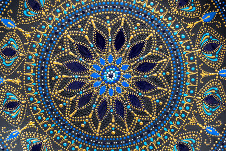 Decorative ceramic plate with black, blue and golden colors, painted plate on background, closeup,...