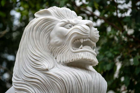 Marble white lion statue in outdoors park, Vietnam. Close up