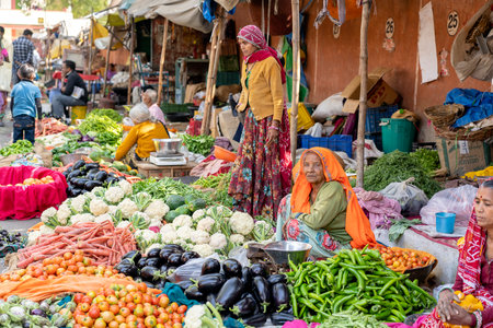 JAIPUR, INDIA - NOVEMBER 25, 2018: Food trader selling vegetables in the street market in holy city Jaipur, Rajasthan, Indiaのeditorial素材