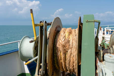 A thick rope is wrapped around a drum on deck of a ferry boat, Thailand. Close up