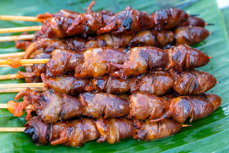 Thai street vendor sells grilled chicken hearts at street food market in island Koh Phangan, Thailand. Close upの写真素材
