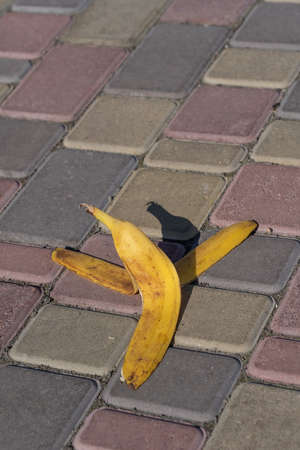 Banana peel was left on the pavement. The danger may slip. If anyone walks on it. Be careful of slippery. Close up, outdoorsの写真素材