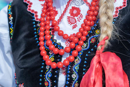 Colorful clothes with beads on at young girls during a festival in Ukraine. Close up