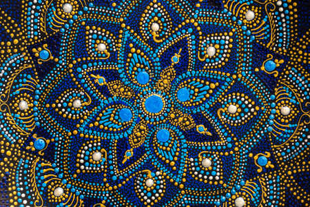 Decorative ceramic plate with black, blue and golden colors, painted plate on background, closeup,...