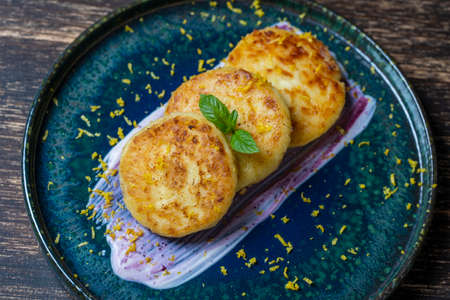 Cheesecakes with mint and sour cream. Delicious dessert, ukrainian food. Close up, top viewの写真素材