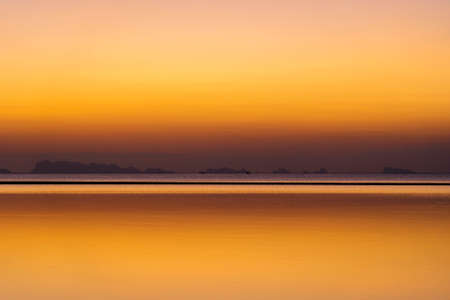 Beautiful sunset over the sea water on the island of Koh Phangan, Thailand. Travel and nature concept. Evening sky and sea waterの写真素材