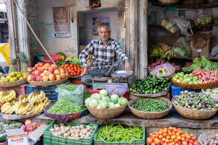 PUSHKAR, INDIA - NOVEMBER 11, 2018: Man selling vegetables in the street market in holy city Pushkar, Rajasthan, Indiaのeditorial素材