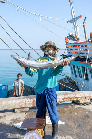 KOH PHANGAN, THAILAND - FEBRUARY 07, 2019: Thai fisherman shows caught big fish on the pier near...