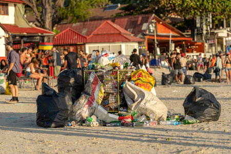 KOH PHANGAN, THAILAND - FEBRUARY 21, 2019: Rubbish on a sandy beach near the sea after a Full Moon party in island Koh Phangan, Thailandのeditorial素材