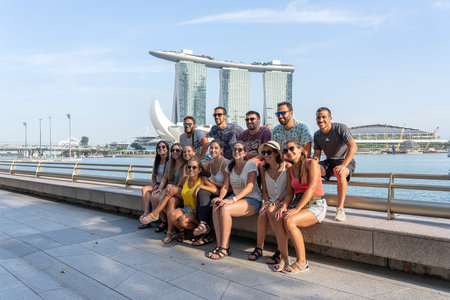 SINGAPORE CITY, SINGAPORE - MARCH 29, 2019: Young people from Europe are photographed against the background of Marina Bay Sands for memory of visiting Singaporeのeditorial素材