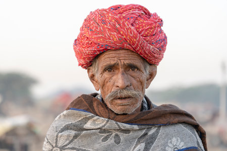 PUSHKAR, INDIA - NOVEMBER 12, 2018: Indian man in the desert Thar during Pushkar Camel Mela near...