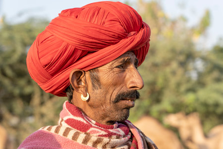 PUSHKAR, INDIA - NOVEMBER 14, 2018: Indian man in the desert Thar during Pushkar Camel Mela near holy city Pushkar, Rajasthan, India. This fair is the largest camel trading fair in the world.のeditorial素材