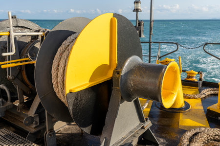 Yellow and black painted ferry deck boat along with the a thick mooring rope and blue sea water wave, Thailand. Close upの写真素材