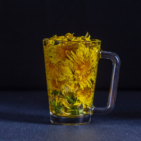 Dandelion yellow flower tea drink in glass, close up. Concept of healthy eating. Herbal tea in glass...