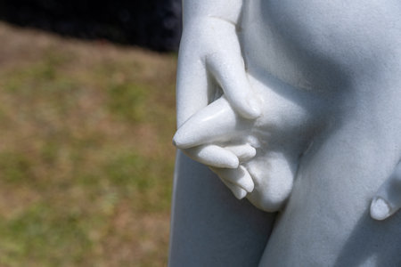 Detail marble statue of naked pissing boy in tropical garden in Danang, Vietnam, close upの写真素材