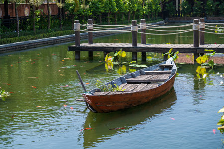Wooden boat on the pond near the pier in a tropical garden in Danang, Vietnam. Travel and nature conceptの写真素材