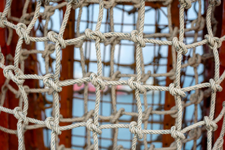 Safety net on boat. Ropes on boat. Safety ropes and blue sea, close up
