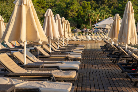 Empty sunbeds and parasols on morning, by the sea. Sand beach in luxury hotel resort near sea. Beautiful morning seascape. Bodrum, Turkeyの写真素材