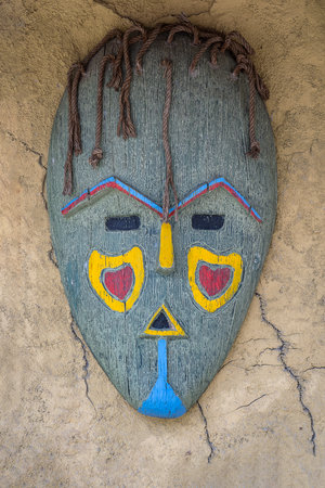 Colorful African mask on a stone wall background, close upの写真素材
