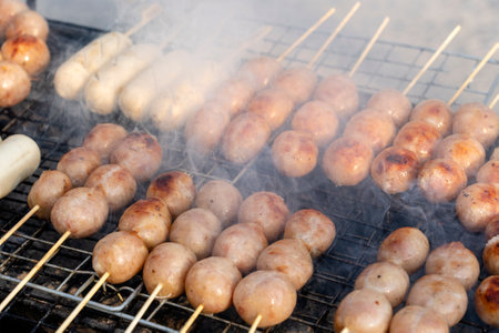 Grilled Thai sausage at street food market in Thailand, close up. Traditional Thai sausage with pork and rice, delicious street food.の写真素材