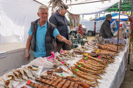 Slavuta, Ukraine - September 22, 2019: Ukrainian man sell smoked fish in the Ethno-eco festival...