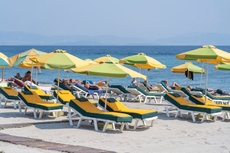 Sunbeds and parasols on morning, by the sea water. Beach in luxury resort near sea. Beautiful morning seascape. Tourist places. Mediterranean beach, a place holidays in summer. Kos island, Greeceの写真素材