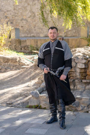 MTSKHETA, GEORGIA - OCTOBER 27, 2018: Georgian man in national costume on a sunny day on street in historical town Mtskheta near Tbilisi, Georgiaのeditorial素材