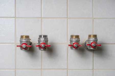 Water taps for connecting a gas boiler on tiled wall. The concealed faucet with connected pipes is mounted in the wall. Close upの写真素材