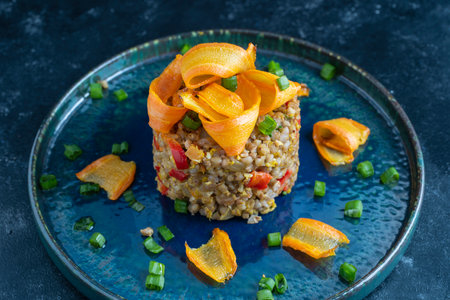 Boiled buckwheat with fried eggs, red peppers, carrots and onions, close up, Ukraine. Food background. Healthy foodの写真素材