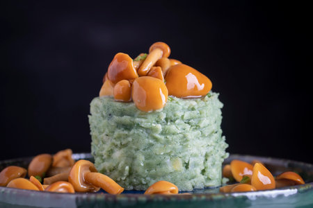 Mashed potatoes with green spirulina and honey mushrooms in a plate, close upの写真素材