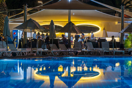 Didim, Turkey - September 02, 2019: Illuminated swimming pool next to the tourist resort hotel on the beach at night. Didim, Turkey. The concept of vacation and travelのeditorial素材