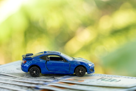 Blue car model on dollar bills, close up. Business concept