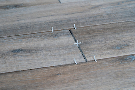 Laying ceramic tiles using plastic crosses. Renovation or repair concept. Close upの写真素材