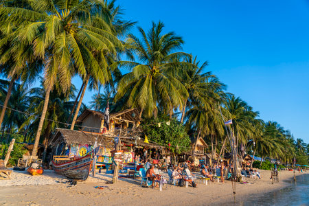 Koh Phangan, Thailand - january 27, 2020: Beach bar, coconut palm trees, sea water and rest people during sunset at tropical island Koh Phangan, Thailandのeditorial素材