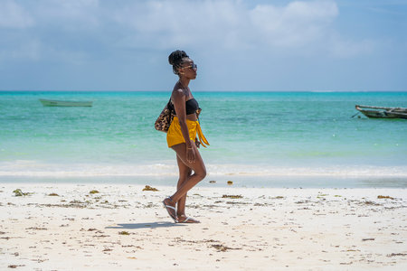 Zanzibar, Tanzania - january 04, 2020: African woman on the tropical beach near sea in island of Zanzibar, Tanzania, east Africaのeditorial素材