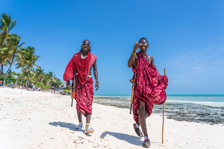 Zanzibar, Tanzania - january 17, 2020: African two men masai dressed in traditional clothes near the ocean on the sand beach of Zanzibar island, Tanzania, East Africa, close upのeditorial素材