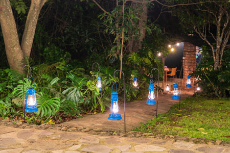 Many kerosene lamps illuminate the road in the tropical garden. Tanzania, east Africaの写真素材