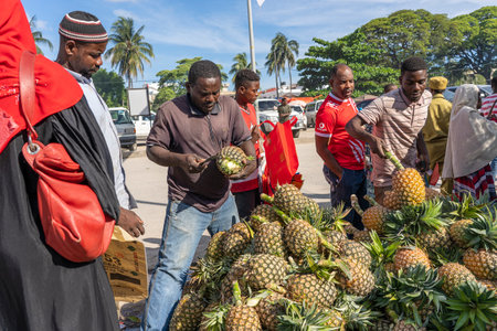 Zanzibar, Tanzania - November 14, 2019: African man sells tropical fruit at a local street food market on the island of Zanzibar, Tanzania, east Africaのeditorial素材