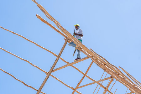 Zanzibar, Tanzania - november 11, 2019: Unknown african man working on the roof of Zanzibar island, Tanzania, East Africa, close upのeditorial素材